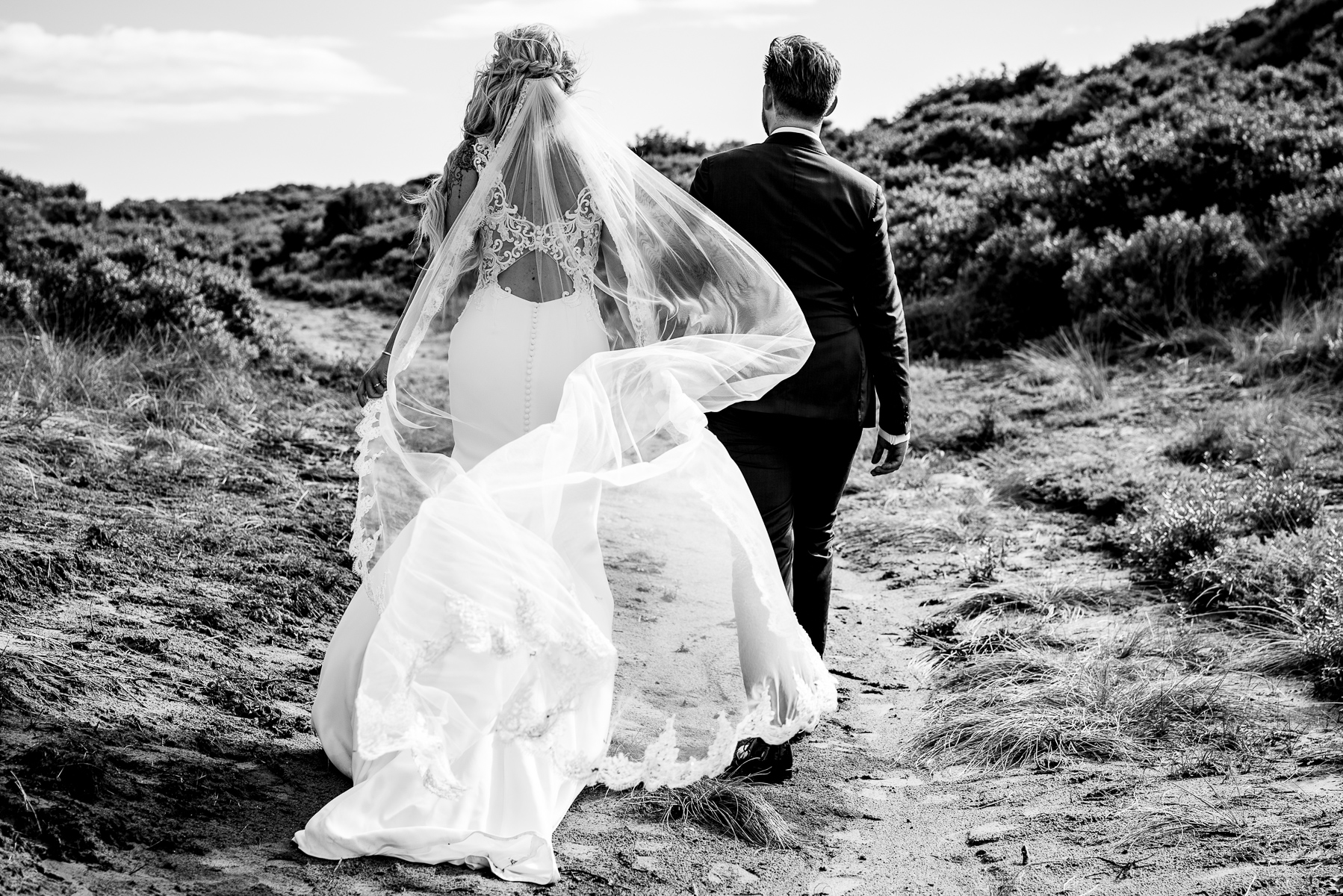 Bruidspaar wandelt samen door de duinen